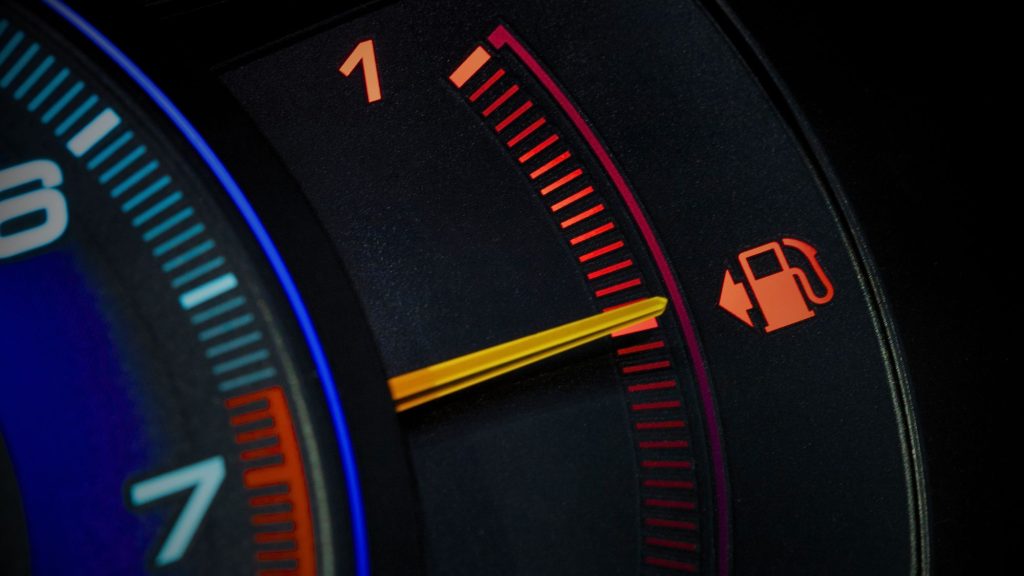 Close-up of car speedometer displaying fuel efficiency and engine performance